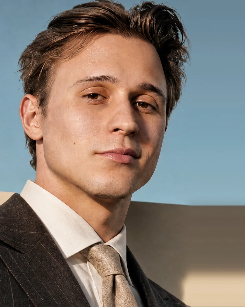 Slava Ploshkin in a pinstripe suit against a blue sky