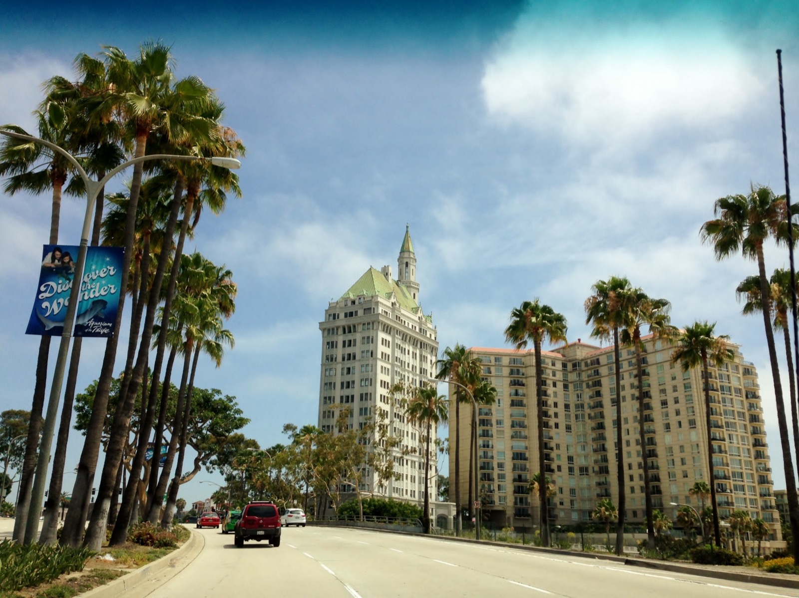 Palm-lined Ocean Boulevard with the green-roofed Villa Riviera tower in the distance at Alamitos Beach in Long Beach, California