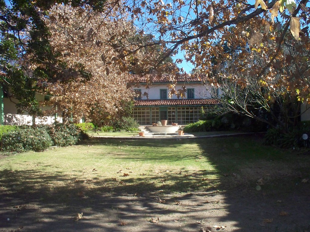 The Monterey-style Rancho Los Cerritos adobe behind its garden lawn and fountain, framed by mature trees in Bixby Knolls, Long Beach